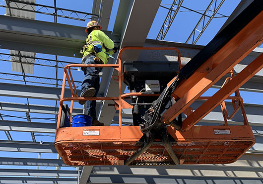A worker installs snapping bolts for an Amazon warehouse under construction in Brooklyn, NY.